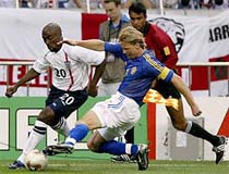Sweden's captain Johan Mjallby slides in to tackle Darius Vassell of England 