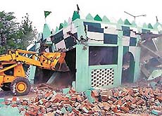 A JCB removes an illegal structure in Sector 55, Chandigarh, on Monday