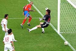 Costa Rica's Mauricio Wright scores past China's goalkeeper