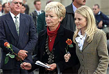 Hansie Cronje's mother San-Marie and widow Bertha carry roses to place on the coffin 