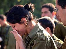 An Israeli female soldier weeps at the bomb blast site