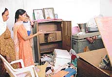 Paramjit Kaur shows the ransacked house and broken locks of an almirah