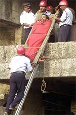 A man is pulled on a stretcher by rescue workers during a mock drill in Mumbai 