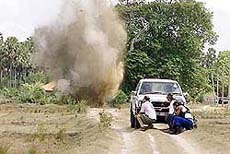 US de-mining experts take cover behind their vehicle
