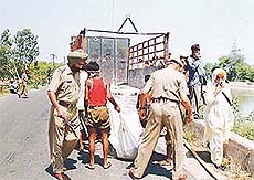 Cops load a body in a truck