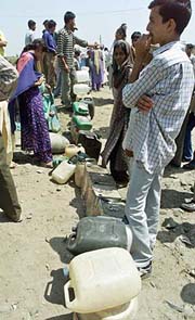 Refugees queue to receive cooking oil