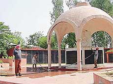 Workers clean fly ash on the war memorial of