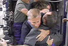 In this image from TV, NASA astronaut Kenneth Cockrell hugs astronaut Carl Walz,