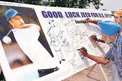 Golfers and golfing fans sign a good luck board at the Chandigarh Golf Club on Sunday to wish local lad Chiranjeev Milkha Singh all the best as he prepares to take part in the US Open. 