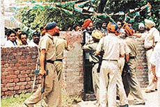 Policemen close the main gate of a polling station to prevent the entry of voters.