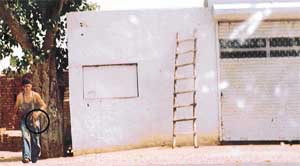 A liquor-vend worker on the Dehlon-Gujjarwal road brings a liquor bottle