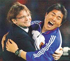 Japan�s team coach Phillippe Troussier celebrates with his assistant coach Masakuni Yamamoto