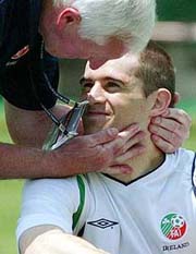 Ireland team physiotherapist Mick Byme hugs midfielder Kevin Kilbane