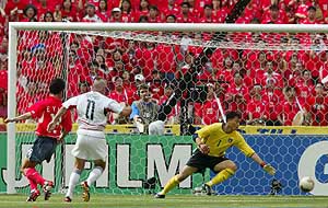 US player Clint Mathis scores as South Korea's goalkeeper Lee Woon jae fails to stop the ball as Hwang Sun Hong looks on in a group D match at the World Cup in Taegu, on Monday. 