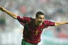 Portugal's Pauleta runs in the rain to celebrate after he scored his second goal 