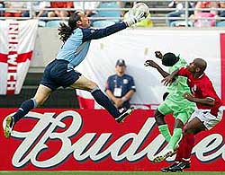 England's goalkeeper David Seaman catches the ball ahead of Nigeria's Joseph Yobo 