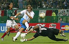 Italy�s Francesco Totti  shoots past the outstretched arms of Mexico�s goalkeeper 