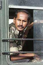 A soldier looks back from a bus as he leaves for his hometown