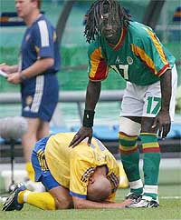 Senegal's Ferdinand Coly consoles Sweden's Henrik Larsson