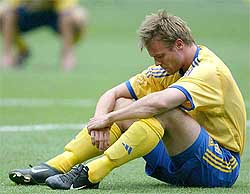 Sweden's Tobias Linderoth sits on the grass as he reacts after losing the second round match 