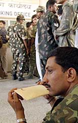 A soldier sits holding travel documents at the booking hall of the railway station in Jaisalmer.