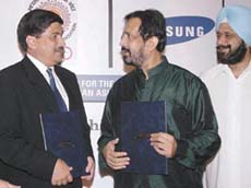 Indian Olympic Association president Suresh Kalmadi and secretary Randhir Singh with R Zutshi of Samsung after signing an MoU with the Korean company. 