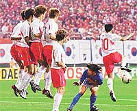 Italian midfielder Damiano Tommasi  ducks as a wall of South Korean defenders jumps to block a free kick