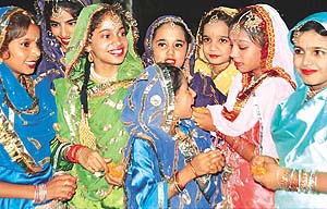 A participant prepares her fellow dancer before performing giddha in a Punjab folk dances contest, organised by the Ghoomer Academy of Arts and Culture at Tagore Theatre 