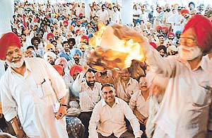 Government employees burn a copy of the Punjab Budget 