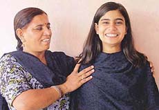 Sonu Kalyan, who has topped the district in Class X Haryana School Education Board examination by securing 82.17 per cent, flanked by her mother 