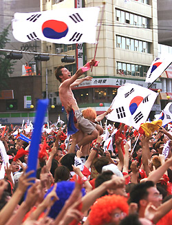 South Korean soccer fans celebrate their team's win in the World Cup quarter-final soccer match between South Korea and Spain in central Seoul on Saturday.