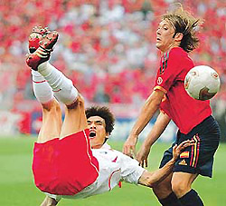 Spain's Gaizka Mendieta looks on as South Korea's Choi Jin-cheul tumbles after missing an overhead shot during extra time of their World Cup quarter-final match in Kwangju, on Saturday.