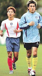 South Korea's goalkeeper Kim Byung-ji (R) runs with Lee Chun-soo during team training at the Misari soccer ground in Hanam, east of Seoul 
