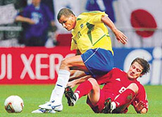 Brazil's Rivaldo (L) falls on Turkey's Tugay Kerimoglu while battling him for the ball during their World Cup semifinal match in Saitama on Wednesday.