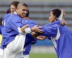 Brazil's Ronaldo  stretches with the help of team-mate Ronaldinho
