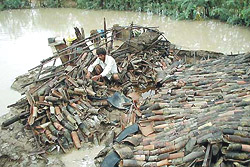 A man sits atop his house