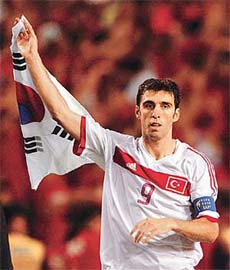 Turkey�s Hakan Sukur waves the South Korea flag 