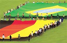 Volunteers carry giant flags of Germany and Brazil