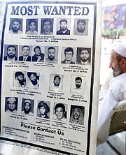 A Pakistani man sits next to a newspaper