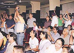 Excited viewers stand in applause while watching the World Cup Football final at Kiran Theatre