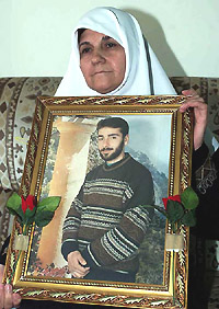 The mother of Palestinian top Hamas bomb-maker Muhanad al-Taher holds his photo