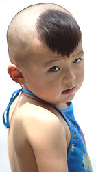 A Chinese boy sports a �Ronaldo� hairstyle as he wears a traditional Chinese undergarment during a family outing in Beijing on Tuesday. 