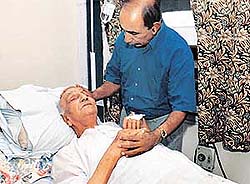 Sardar Kultar Singh, younger brother of Shaheed Bhagat Singh, being attended by his son Zoravar Singh in a private ward of the PGI, Chandigarh, on Wednesday.