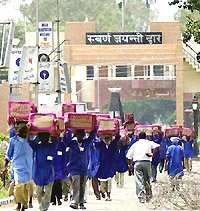 Porters carry boxes of almonds exported from Afghanistan at the Wagah border on Thursday.