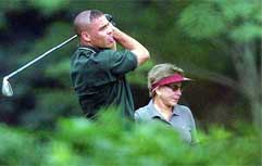Brazilian soccer star Ronaldo hits a fairway iron