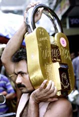 A labourer holds a 50-kg lock