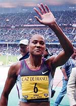 Marion Jones of the USA celebrates as she wins the women's 100 metres during the Paris Golden League athletic meeting