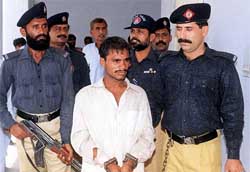 One of the four alleged rapists is escorted by the police