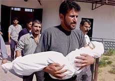 �Zakaria Hindi carries the body of his 2-year-old niece Noor