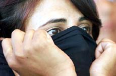 An unidentified supporter of the Congress party hides her face